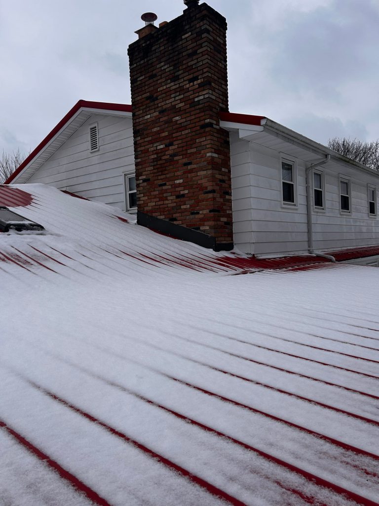 Residential house with a metal roof covered in snow